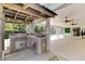 Outdoor kitchen with stainless grill and sink, attached to the screened in lanai at 23647 Seneca Ridge Ct, Christmas, FL 32709