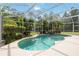 Screened in pool with privacy landscaping and attached waterfall feature at 23647 Seneca Ridge Ct, Christmas, FL 32709