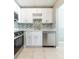 Bright kitchen with stainless steel appliances, white cabinetry, and tile backsplash at 2627 Oak Park Way # 102, Orlando, FL 32822