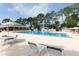 Community pool area with lounge chairs and umbrellas at 2627 Oak Park Way # 102, Orlando, FL 32822
