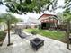 Spacious backyard featuring a patio, fire pit, lush lawn, and a charming upper deck at 312 W Hull Ave, Oakland, FL 34760
