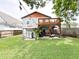Landscaped backyard featuring a patio, lush lawn, upper deck, and outdoor grilling area at 312 W Hull Ave, Oakland, FL 34760