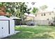 Large backyard featuring outdoor dining, lush lawn, and shed at 312 W Hull Ave, Oakland, FL 34760