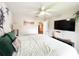 Bright bedroom with large bed, ceiling fan, and a kitchen view through doorway at 312 W Hull Ave, Oakland, FL 34760