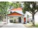 Charming two-story home with a carport, orange accents, and well-maintained landscaping at 312 W Hull Ave, Oakland, FL 34760