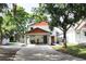 Inviting home showcasing a concrete driveway, covered parking, and a vibrant orange accent trim at 312 W Hull Ave, Oakland, FL 34760