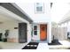 Charming home featuring a welcoming orange front door, neat landscaping, and a covered parking area at 312 W Hull Ave, Oakland, FL 34760