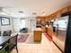 Open kitchen with stainless steel appliances, wooden cabinets, an island, and tile flooring at 312 W Hull Ave, Oakland, FL 34760