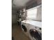 Functional laundry room equipped with a washer, dryer, shelves and storage at 312 W Hull Ave, Oakland, FL 34760