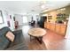 Open-concept living area featuring hardwood floors, kitchen view, and comfortable seating at 312 W Hull Ave, Oakland, FL 34760