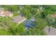Overhead view reveals a screened-in pool area, lush landscaping, and the home's backyard layout at 3231 Furlong Way, Gotha, FL 34734