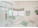 Bright bathroom featuring a glass-enclosed shower and separate tub, providing a spa-like experience at 3231 Furlong Way, Gotha, FL 34734