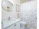 Bathroom with a white vanity, toilet, shower with patterned shower curtain, and a decorative mirror at 3231 Furlong Way, Gotha, FL 34734