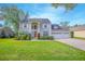 Charming two-story home features a manicured lawn, three-car garage and a welcoming red front door at 3231 Furlong Way, Gotha, FL 34734