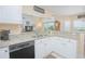 Kitchen with granite countertops, white cabinets, stainless steel dishwasher, and an open view to the living room at 3231 Furlong Way, Gotha, FL 34734