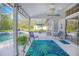 Charming covered patio featuring a ceiling fan, colorful lights, outdoor seating, and views of the screened-in pool at 3231 Furlong Way, Gotha, FL 34734
