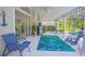Relaxing covered patio with a ceiling fan, tropical rug, comfortable seating, and access to the screened-in pool area at 3231 Furlong Way, Gotha, FL 34734