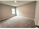 A cozy bedroom features a neutral palette, plush carpeting, and a window for ample natural light at 324 Charles Dr, Deland, FL 32724