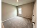 This carpeted bedroom has neutral walls and a window, providing a blank canvas for personalization at 324 Charles Dr, Deland, FL 32724