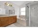 Bright bathroom featuring dual vanities, a soaking tub, and a separate glass-enclosed shower at 3390 Cypress Point Cir, St Cloud, FL 34772