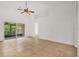 Bright living room with tile flooring, ceiling fan, and sliding glass door to screened lanai at 3390 Cypress Point Cir, St Cloud, FL 34772