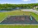 Community playground featuring swings, slide, and monkey bars, near a lake and green space for outdoor recreation at 3390 Cypress Point Cir, St Cloud, FL 34772