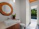 Bathroom featuring wood cabinets, a modern sink, unique mirror and a view of the pool at 340 Lakeview Rd, Winter Garden, FL 34787