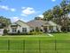 Stunning white farmhouse-style home featuring a beautifully landscaped front yard with a black metal fence and lush green grass at 340 Lakeview Rd, Winter Garden, FL 34787