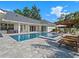 A luxurious pool with a spa, sun loungers, and shaded pergola, perfect for outdoor relaxation at 340 Lakeview Rd, Winter Garden, FL 34787