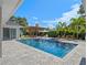 Resort-style pool with a pergola-covered lounge area, sun loungers, and lush landscaping at 340 Lakeview Rd, Winter Garden, FL 34787