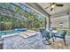The screened backyard patio features a pool, spa, seating, a ceiling fan and beautiful landscaping at 384 Old Alemany Pl, Oviedo, FL 32765
