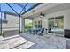 Screened outdoor patio with blue cushioned seating, pavers and view of the backyard pool at 384 Old Alemany Pl, Oviedo, FL 32765