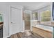 The bathroom features a separate glass shower and a soaking tub with tiled surround beneath a large window at 384 Old Alemany Pl, Oviedo, FL 32765
