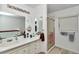 Bright white bathroom with stylish mirror accents, updated vanity and a glass enclosed shower at 40533 E 8Th Ave, Umatilla, FL 32784