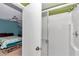 Bright bathroom featuring a glass shower with silver hardware, adjacent to a bedroom with ceiling fan at 40533 E 8Th Ave, Umatilla, FL 32784