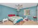 A bedroom featuring blue walls, carpet, decor with a beach theme and a ceiling fan at 40533 E 8Th Ave, Umatilla, FL 32784
