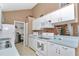 Traditional kitchen features white appliances, matching cabinetry, blue countertops and access to an adjacent room at 40533 E 8Th Ave, Umatilla, FL 32784