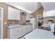 Galley kitchen featuring white cabinets, laminate counters, and appliances, offering a bright and functional space at 40533 E 8Th Ave, Umatilla, FL 32784