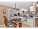 Kitchen with a glass-top dining table, white cabinets, and a refrigerator, providing a functional and bright space at 40533 E 8Th Ave, Umatilla, FL 32784