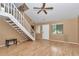 Spacious living room featuring wood laminate floors, a staircase, windows, and a white front door offering natural light at 40533 E 8Th Ave, Umatilla, FL 32784