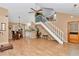 Open-concept living area featuring a vaulted ceiling, wood laminate floors, staircase, and a kitchen breakfast bar at 40533 E 8Th Ave, Umatilla, FL 32784