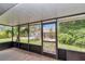 Screened-in porch with tile flooring and views of the backyard and lush greenery at 40533 E 8Th Ave, Umatilla, FL 32784