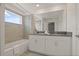 Bright bathroom featuring a tub-shower combo, double sink vanity, and large mirror at 4363 Scene Ln, Kissimmee, FL 34746