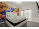 Comfortable bedroom with mural, a plush bed and bright natural light at 4363 Scene Ln, Kissimmee, FL 34746