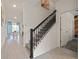 Bright entryway showcasing staircase with black railings, tile floors, and dining area at 4363 Scene Ln, Kissimmee, FL 34746