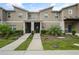 Inviting townhouse showcasing a modern design, landscaped front yard, and a neatly paved walkway at 4363 Scene Ln, Kissimmee, FL 34746