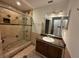 Tiled bathroom featuring a glass-door shower, modern vanity, and a mirror above the sink at 4756 Walden Cir # 21, Orlando, FL 32811
