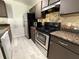 Compact kitchen featuring modern appliances and ample counter space with tiled backsplash at 4756 Walden Cir # 21, Orlando, FL 32811