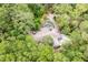 An aerial view of a home with a uniquely shaped pool nestled among lush trees at 4933 Round Lake Rd, Apopka, FL 32712