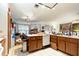 View of the cluttered kitchen featuring wooden cabinets, white appliances, and a dining area at 4933 Round Lake Rd, Apopka, FL 32712
